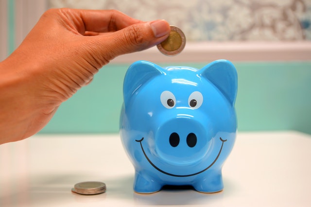 Person saving money in a piggy bank. 