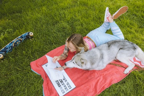 a girl and a husky in a dog park