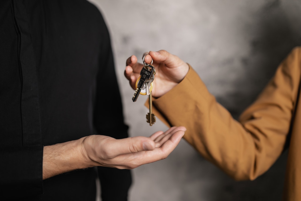One person handing a set of house keys to another.