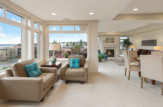 a large living room with beige tones and blue pillows