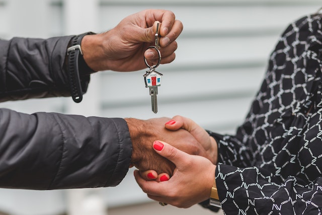 Man shaking a woman's hand and giving her the keys
