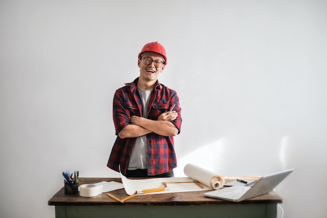 A man standing beside a table with papers