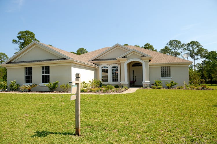 A house with a For Sale sign in the front yard.